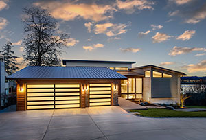 A lovely home with a three-car garage. The garage doors are lit from within with 6 horizontal lines running from side to side